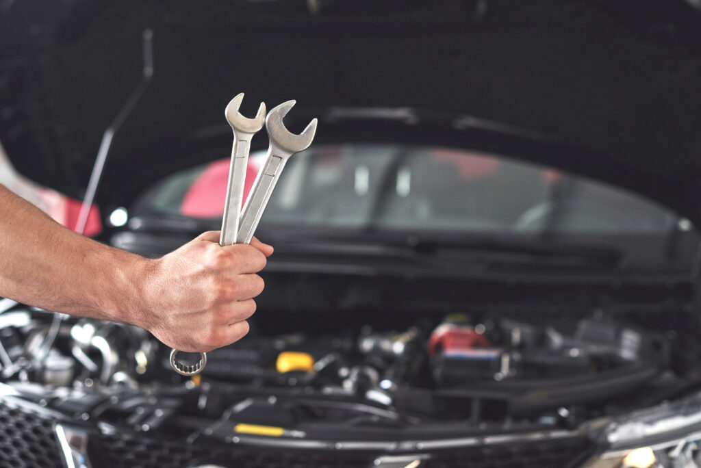 Mecánico con llaves frente al motor: herramientas para diagnosticar por qué el carro no enciende.
